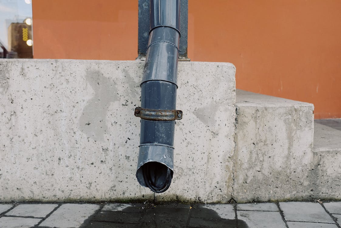 Water dripping out of a drainage spout.